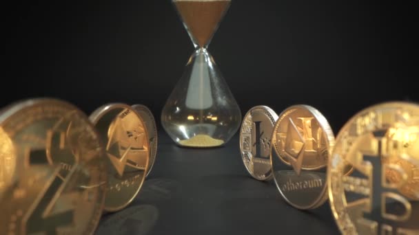 Hourglass με άμμο και χρυσά ψηφιακά crypto νομίσματα ZCASH, Bitcoin, Etherium, Litecoin, Ripple, Χρυσή αντανάκλαση στην επιφάνεια. Μαύρο φόντο. Δυνατό ψηφιακό νόμισμα. Ο χρόνος τελειώνει. — Αρχείο Βίντεο