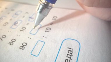 Okul çocuğu ev ödevini yapıyor. Karmaşık denklemleri çözüyor ve sonra kamera yazıt zaferine yöneliyor. Makro çekim