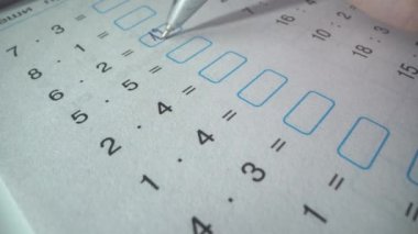 Matematik sınavında zor bir görev. Öğrenci denklemleri çözer. Doğru cevapları yazıyor. Okul hayatı. Kalemle yazmış..