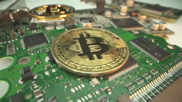 Investice do Bitcoinu. Obchodník dal 2 zlaté digitální kryptografické mince do mikročipu. Polovina bitcoinu. Obchodování. Koupit bit coin — Stock video