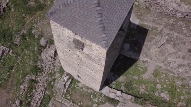 VERHNAYA BALKARIA, Ryssland - AUGUST 15 2020: Ruind city in the middle of the majestic mountains. Forntida stenbyggnad i gamla stan ligger på grön kulle mot berg täckta med skog och dimma — Stockvideo