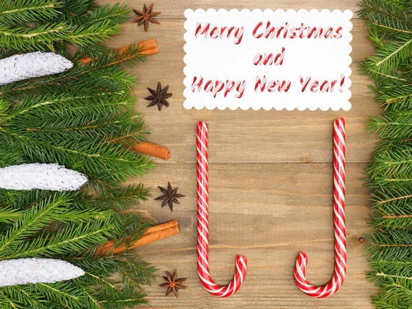 Коричневий дерев'яний різдвяний фон з ялинковими гілками, карамеллю, сі. — стокове фото