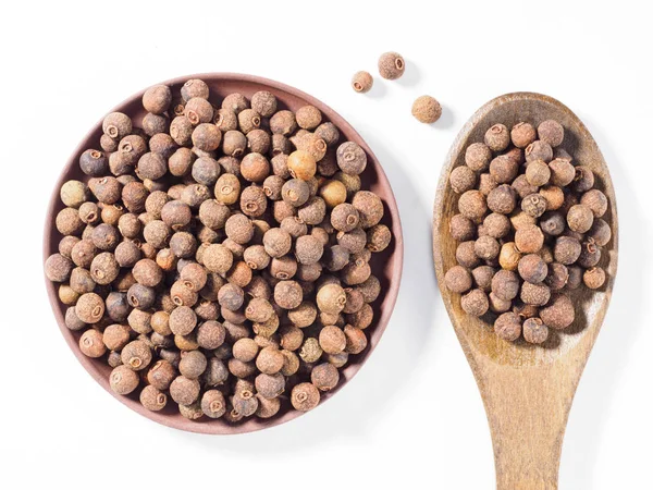 Allspice (Jamaica peper) in kleiplaat en houten lepel vertica — Stockfoto