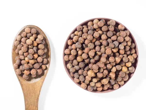 Allspice (pimienta de Jamaica) en el plato de barro y cuchara de madera ver —  Fotos de Stock