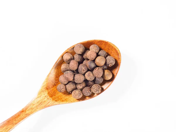Pimento (pepe di Giamaica) nel cucchiaio di legno diagonalmente su whit — Foto Stock