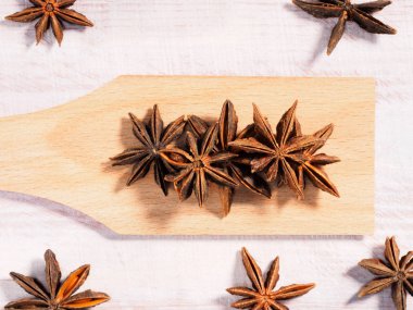 Anise (Anisum vulgare) bir kaşık üzerinde ahşap arka planda 