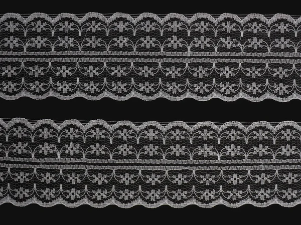Siyah bir arka plan üzerinde beyaz dantel — Stok fotoğraf