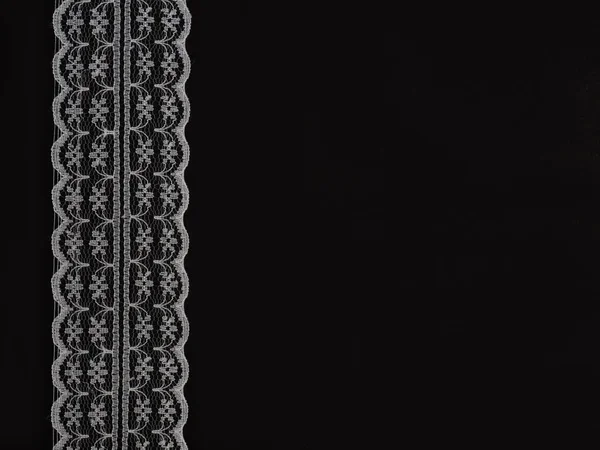 Białe sznurowadła na czarnym tle pionowo w rzędzie — Zdjęcie stockowe