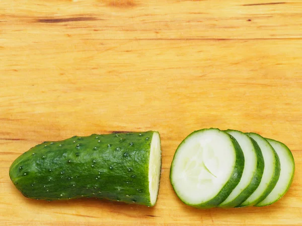 Gehakte groene komkommer op houten ondergrond — Stockfoto