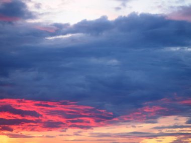 Gökyüzündeki gök gürültülü bulutlar güneş ışınlarıyla aydınlatılıyor. 