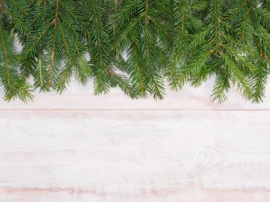 Christmas background with fir branches on brown wooden backgroun