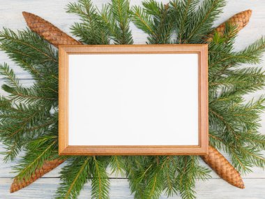 Fir tree branch with frame, cones. Winter holidays concept