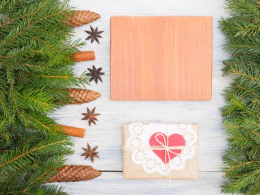 Fir tree branch with cones, cinnamon, anise, nameplate on white 