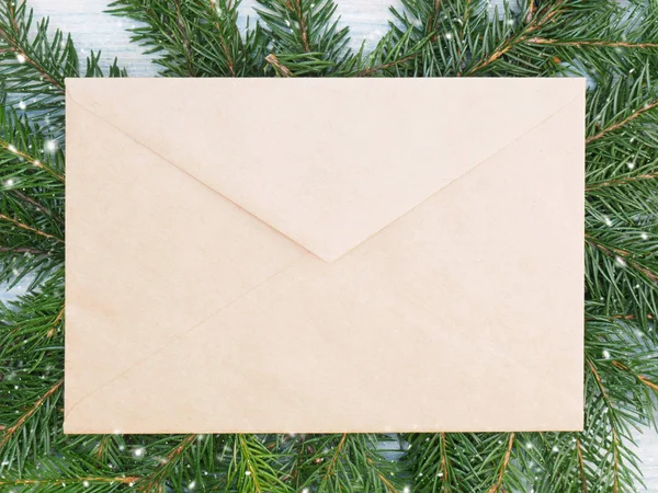 Tannenzweig mit Umschlag, Schneeflocke auf weißem Holzbackgro — Stockfoto