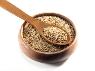 Kimyon tohumları (Cuminum), tahtadan bir kap içinde jeera ve beyaz bir kaşık 