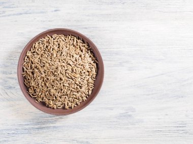 Kimyon tohumları (Cuminum), Jeera beyaz ahşap bir levhada.