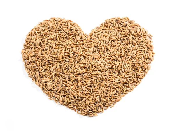 Cumin seeds (Cuminum), jeera in the shape of a heart on a white Royalty Free Stock Images