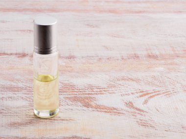 Sarı kozmetik sprey şişesi dikey olarak ahşap arka planda
