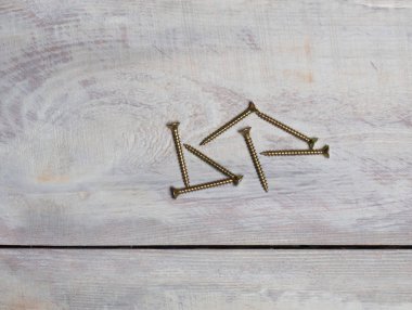 Açık kahverengi arka planda çelik vidalar grubu