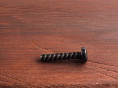 Kahverengi arka planda fotokopi alanı olan bir vida. Sanayi teması