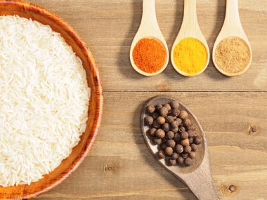 Pirinç, acı biber, baharat, masala, kahverengi ahşap üzerinde zerdeçal.
