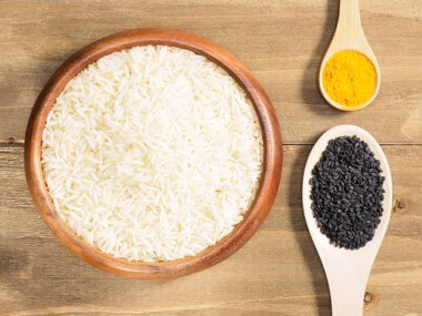 Pirinç, zerdeçal, kahverengi ahşap arka planda siyah kimyon. Hint c