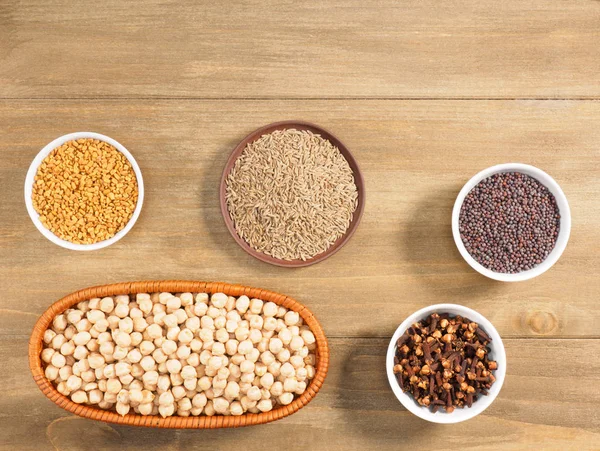 Mung bean, mustard seeds, fenugreek, cumin, cloves on brown wood — Stock Photo, Image