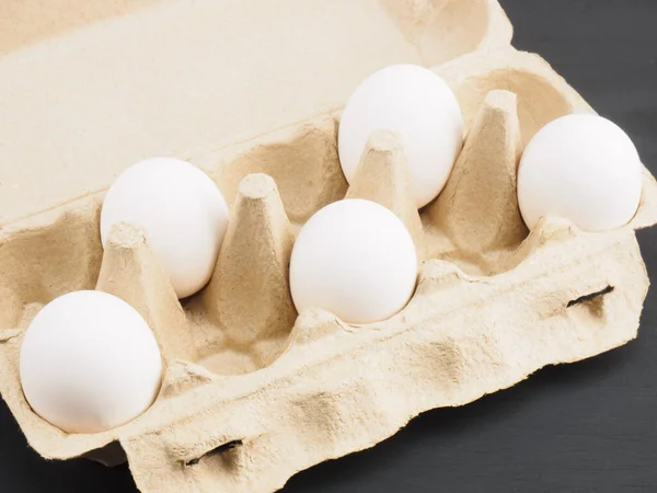黒の木の背景にパックあたり5生の白い鶏の卵 健康的な食事と有機食品の概念 — ストック写真