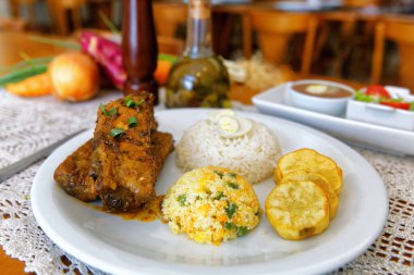 Yanında pirinç, farofa, tatlı patates, fasulye ve salata ile birlikte kızarmış domuz kaburgası.. 