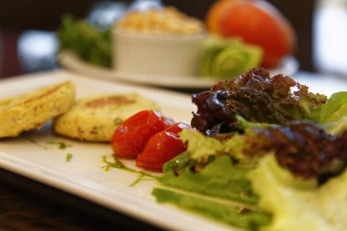 Marul, roka ve domates salatalı vejetaryen burger.