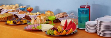 Kahvaltıda kekler, jöleler, mısır gevrekleri, meyveler ve meyve suyu..