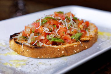 Peynirli ve sarımsaklı kızarmış ekmeğe domatesli, otlu ve yağlı