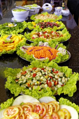 Salatalı, etli, pirinçli ve balıklı yemek servisi..