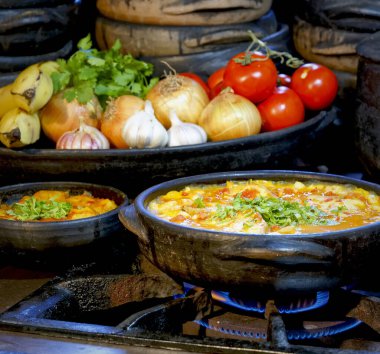 Delicious Moqueca capixaba and vegetables  in the clay pots clipart