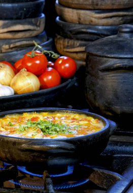 Lezzetli Moqueca capixaba ve kil kaplarda sebzeler