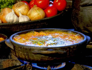 Lezzetli Moqueca capixaba ve kil kaplarda sebzeler