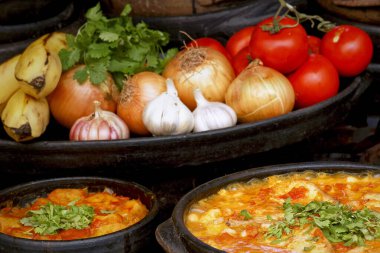 Lezzetli Moqueca capixaba ve kil kaplarda sebzeler