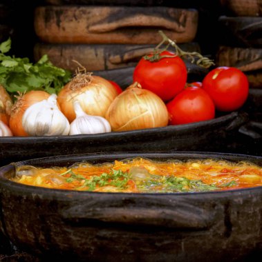 Lezzetli Moqueca capixaba ve kil kaplarda sebzeler