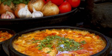 Lezzetli Moqueca capixaba ve kil kaplarda sebzeler