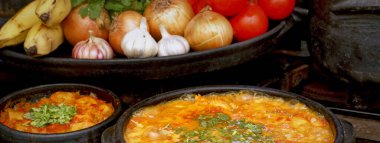 Lezzetli Moqueca capixaba ve kil kaplarda sebzeler