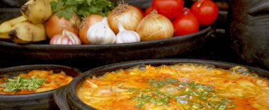 Lezzetli Moqueca capixaba ve kil kaplarda sebzeler