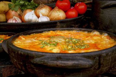 Lezzetli Moqueca capixaba ve kil kaplarda sebzeler