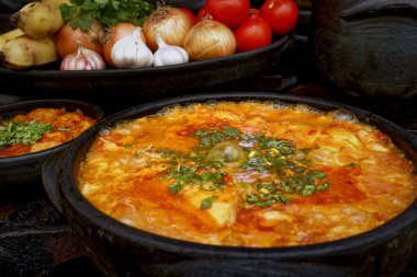 Lezzetli Moqueca capixaba ve kil kaplarda sebzeler