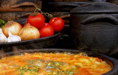 Lezzetli Moqueca capixaba ve kil kaplarda sebzeler