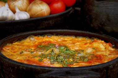 Lezzetli Moqueca capixaba ve kil kaplarda sebzeler