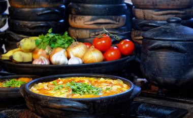 Lezzetli Moqueca capixaba ve kil kaplarda sebzeler