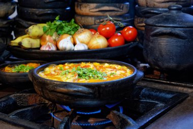 Lezzetli Moqueca capixaba ve kil kaplarda sebzeler