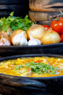 Lezzetli Moqueca capixaba ve kil kaplarda sebzeler