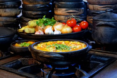 Lezzetli Moqueca capixaba ve kil kaplarda sebzeler