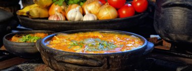 Lezzetli Moqueca capixaba ve kil kaplarda sebzeler